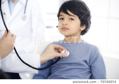 Doctor-woman examining a child patient by stethoscope. Cute arab boy at physician appointment. Medicine concept Doctor-woman examining a child patient by stethoscope. Cute arab boy at physician appointment. Medicine concept 78598854