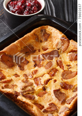 Swedish food ugnspannkaka or Flaskpannkaka oven pancake with pork close up in the baking dish. Vertical 78601637