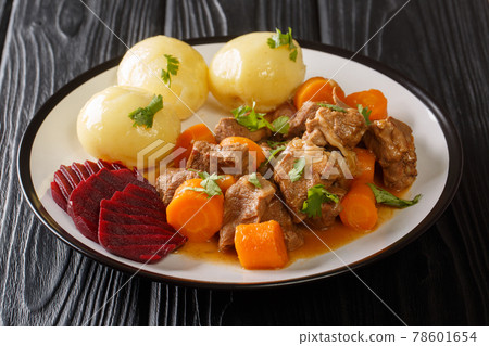Swedish traditional beef kalops garnished with boiled potatoes and pickled beets close-up in a plate. horizontal Swedish traditional beef kalops garnished with boiled potatoes and pickled beets close-up in a plate. horizontal 78601654