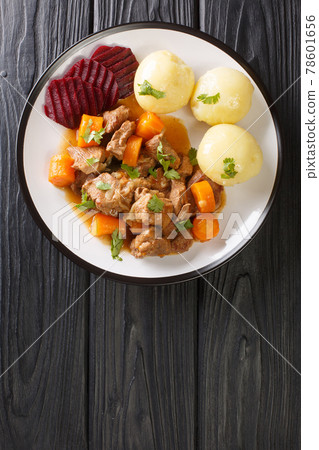 Beef stew with a side dish of boiled potatoes and pickled beets close-up in a plate. vertical top view Beef stew with a side dish of boiled potatoes and pickled beets close-up in a plate. vertical top view 78601656