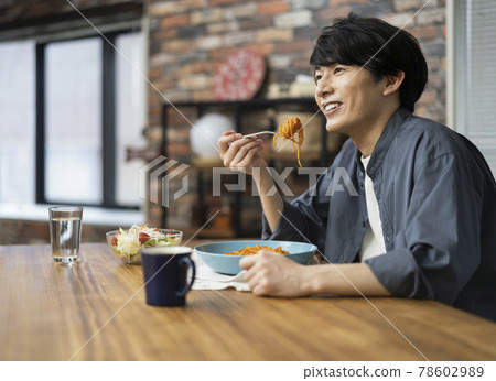 一個二十多歲的男人吃意大利面 78602989