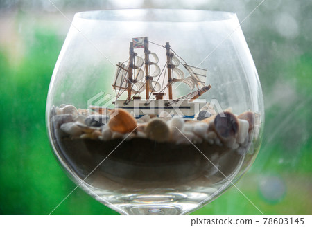 White sailing yacht in a glass with shells White sailing yacht in a glass with shells 78603145
