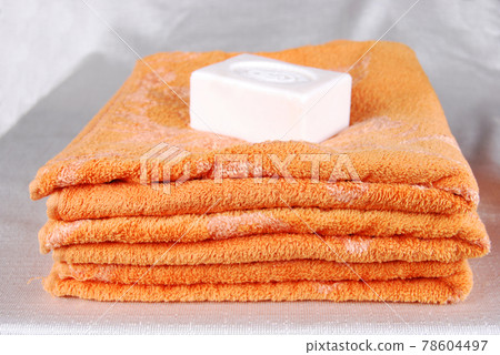 White aromatic, fragrant soap bars and orange towel 78604497