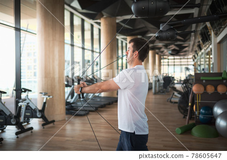 Man exercising in the gym on a pec deck machine for chest workout 78605647
