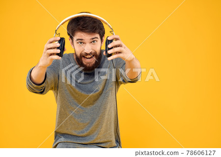 Man in headphones listens to music technology lifestyle fun people yellow background 78606127
