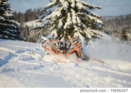 Athlete on a snowmobile moving in the mountains Athlete on a snowmobile moving in the mountains 78606267