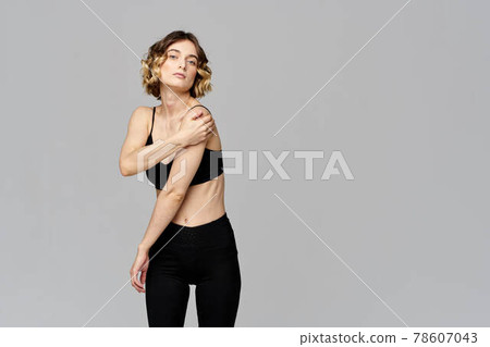 Sporty woman in leggings on a gray background is engaged in fitness Copy Space 78607043