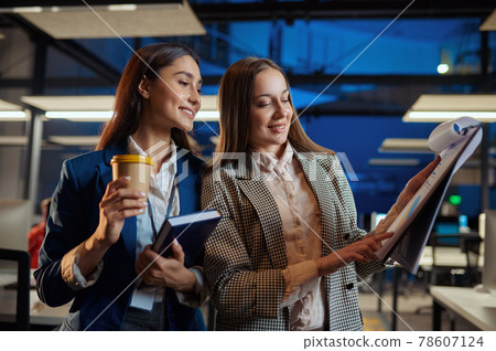 Cheerful women talks in night office Cheerful women talks in night office 78607124
