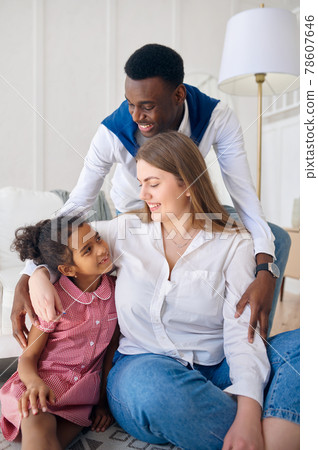 Happy family sitting on the floor in living room Happy family sitting on the floor in living room 78607646