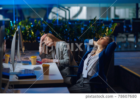 Tired women works on computers in night office Tired women works on computers in night office 78607680