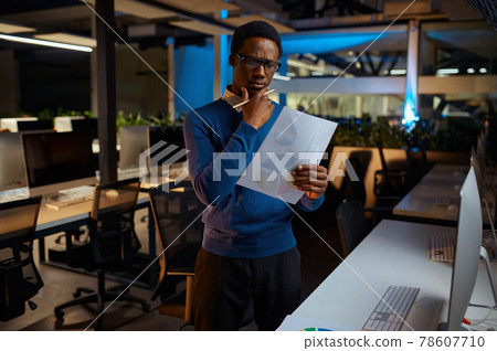 Man in glasses looks at charts, office lifestyle Man in glasses looks at charts, office lifestyle 78607710