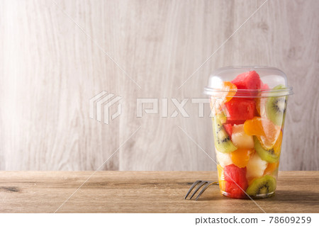 Fresh cut fruit in a plastic cup Fresh cut fruit in a plastic cup 78609259