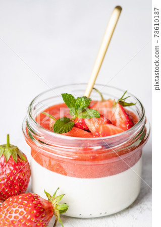 Panna cotta in glass jars with strawberry sauce. 78610187