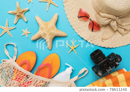 Flat composition with different accessories for a beach holiday on a blue background, summer background Flat composition with different accessories for a beach holiday on a blue background, summer background 78611248