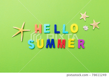 The inscription from multi-colored plastic letters with starfish on a green background 78611249
