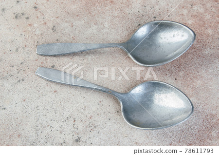 Huge aluminum spoons on concrete background. 78611793