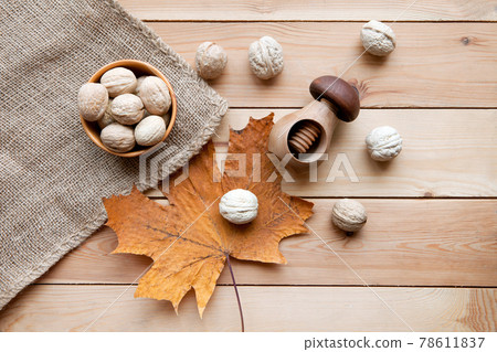 Tasty wallnuts on a wooden table and nutcracer. autum maple leaf and sack. harvest concept and nutrition Tasty wallnuts on a wooden table and nutcracer. autum maple leaf and sack. harvest concept and nutrition 78611837