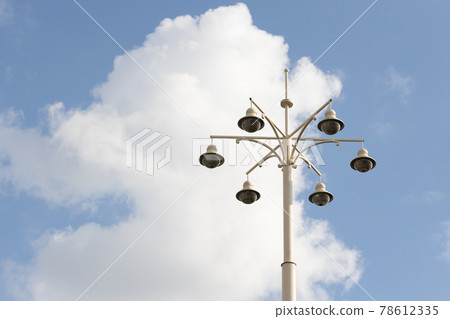 Street lamp with lamps in a classic style against a blue sky. Street lamp with lamps in a classic style against a blue sky. 78612335