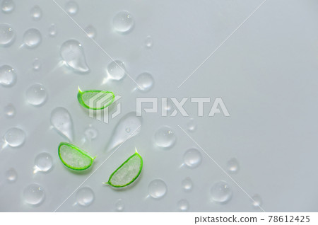 Three cut leaves of aloe vera and drops on gray background. Cosmetics from natural plants and textured serum gel. 78612425
