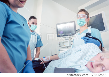Doctor during colonoscopy in hospital looking at screen 78612558