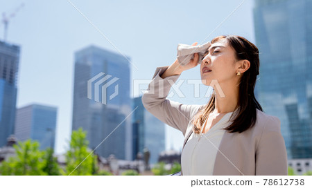 Tired business woman wiping sweat outside 78612738