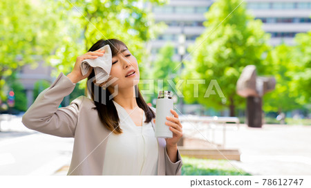 在外面擦汗的同時補充水分的女商人 在外面擦汗的同時補充水分的女商人 78612747
