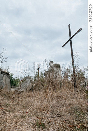 Unnamed gravestones with metal and stone crosses on old abandoned city or village cemetery. Weathered stone cross on abandoned graveyard. Selective focus 78612799