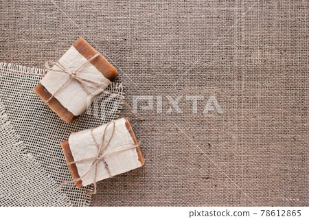 Top view on handmade natural soap bars or dry shampoo with on rustic fabric background with copy space. Close up of home spa products made with natural ingridients and organic essential oils Top view on handmade natural soap bars or dry shampoo with on rustic fabric background with copy space. Close up of home spa products made with natural ingridients and organic essential oils 78612865