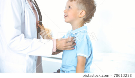 Happy smiling male kid-patient at usual medical inspection. Doctor and young boy in the clinic. Medicine concepts Happy smiling male kid-patient at usual medical inspection. Doctor and young boy in the clinic. Medicine concepts 78613258