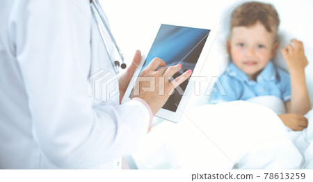 Happy smiling male kid-patient at usual medical inspection. Doctor and young boy in the clinic. Medicine concepts 78613259