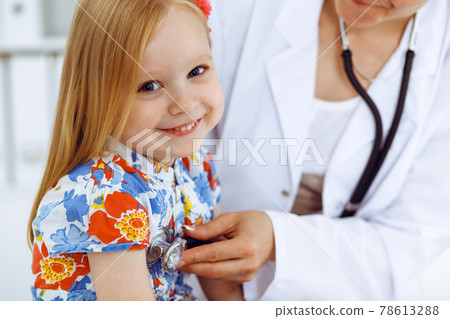 Happy smiling female kid-patient at usual medical inspection. Doctor and young girl in the clinic. Medicine, healthcare concepts 78613288