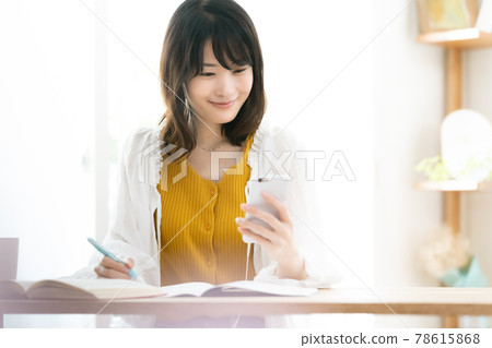 A woman watching a smartphone A woman watching a smartphone 78615868