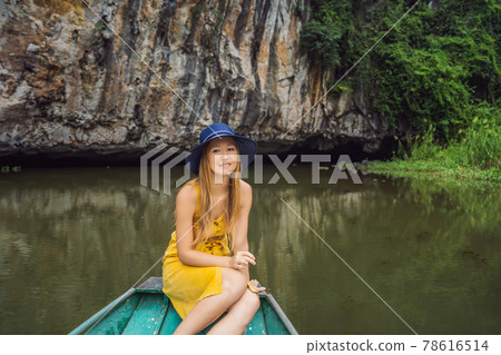 Woman tourist in boat on the lake Tam Coc, Ninh Binh, Viet nam. It's is UNESCO World Heritage Site, renowned for its boat cave tours. It's Halong Bay on land of Vietnam. Vietnam reopens borders after Woman tourist in boat on the lake Tam Coc, Ninh Binh, Viet nam. It's is UNESCO World Heritage Site, renowned for its boat cave tours. It's Halong Bay on land of Vietnam. Vietnam reopens borders after 78616514