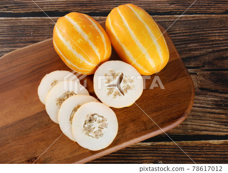 Melon on cutting board with wooden background 78617012