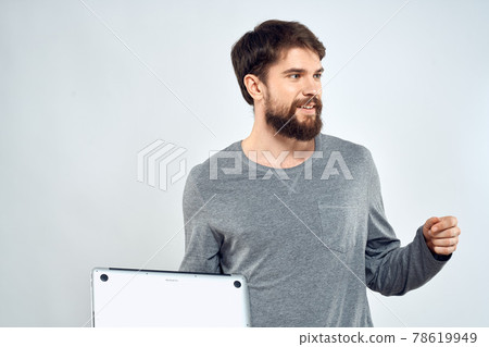 Emotional man holding a laptop success modern style work light background Emotional man holding a laptop success modern style work light background 78619949