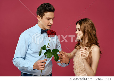 enamored man and woman with a red flower on a pink background hug each other Copy Space enamored man and woman with a red flower on a pink background hug each other Copy Space 78620844