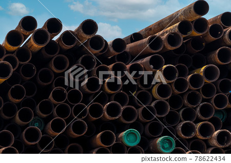 Pile of old rusty round metal industrial pipe. Steel pipe stack at warehouse of factory. Industrial material. Metal corrosion. Stack of rusty tube. Old iron pipe at warehouse. Metal pipe industry. 78622434