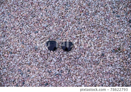 Black sunglasses lying on gravel Black sunglasses lying on gravel 78622793