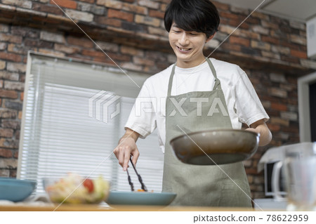 A young man who cooks with an apron A young man who cooks with an apron 78622959