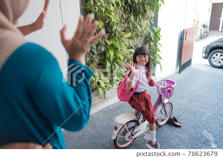 girl primary student going to school by riding a bike in the morning 78623679
