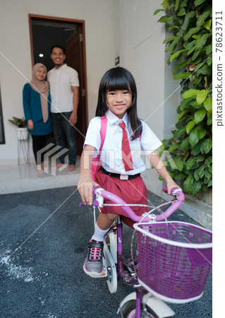 girl primary student going to school by riding a bike in the morning girl primary student going to school by riding a bike in the morning 78623711