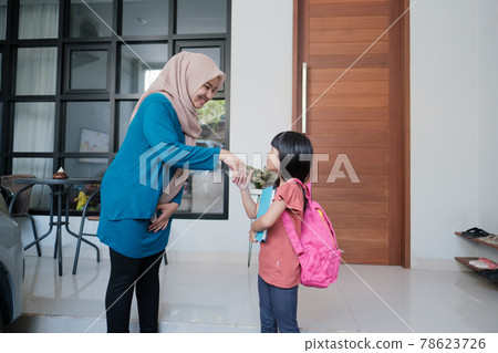 primary school female student shake and kiss her muslim mother's hand before going to school primary school female student shake and kiss her muslim mother's hand before going to school 78623726