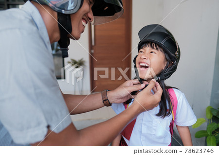 father taking his daughter to school by motorcycle in the morning father taking his daughter to school by motorcycle in the morning 78623746