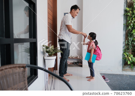 indonesian primary school female student shake and kiss her father's hand before going to school indonesian primary school female student shake and kiss her father's hand before going to school 78623760