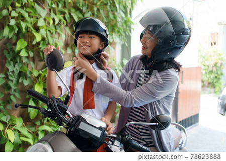mother taking her daughter to school by motorcycle in the morning mother taking her daughter to school by motorcycle in the morning 78623888