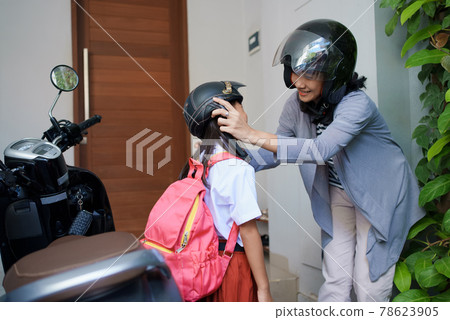 mother taking her daughter to school by motorcycle in the morning mother taking her daughter to school by motorcycle in the morning 78623905