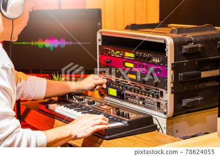 male professional musician playing synthesizer keyboard while editing tone on effect processor equipment in studio, focus on hand. sound design concept male professional musician playing synthesizer keyboard while editing tone on effect processor equipment in studio, focus on hand. sound design concept 78624055