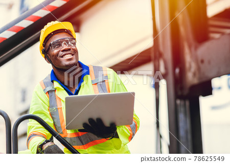 Black African happy worker working in logistic shipping with laptop computer control loading containers at port cargo. Import export shipping industry people. 78625549