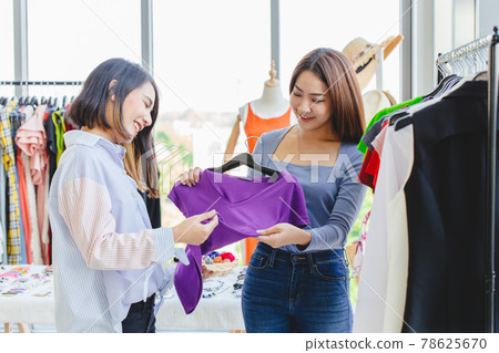 Women customer choosing clothes in fashion shop with business owner care service with happy smile. Women customer choosing clothes in fashion shop with business owner care service with happy smile. 78625670