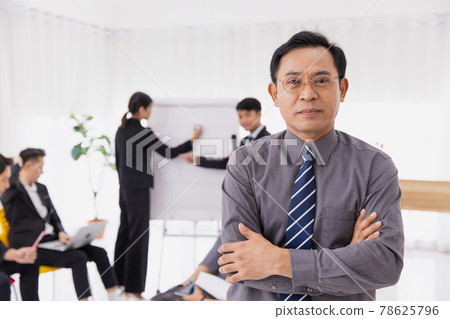 Portrait Asian adult smart businessman confident arm crossed. Business owner male standing with office worker planning management meeting. 78625796